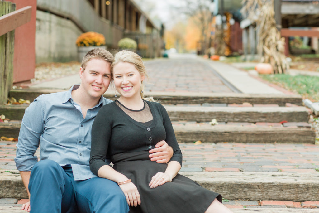 Couple sits on the steps at their Old Bag Factory Engagement Session
